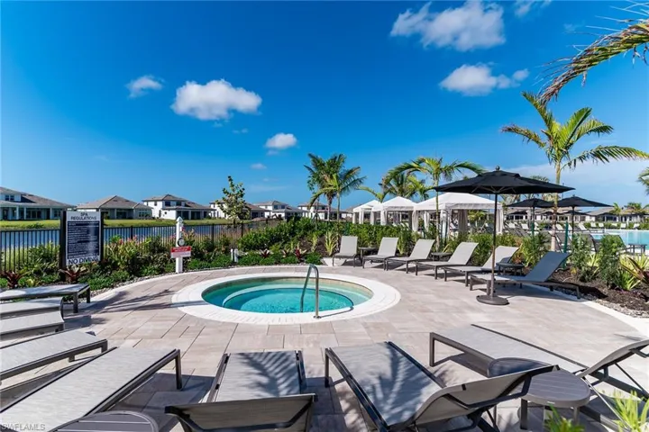 View of swimming pool with a hot tub, a residential view, a water view, fence, and a patio area