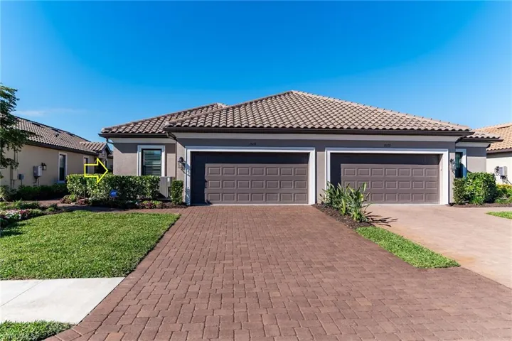 View of front of property featuring decorative driveway, a tile roof, an attached garage, and stucco siding