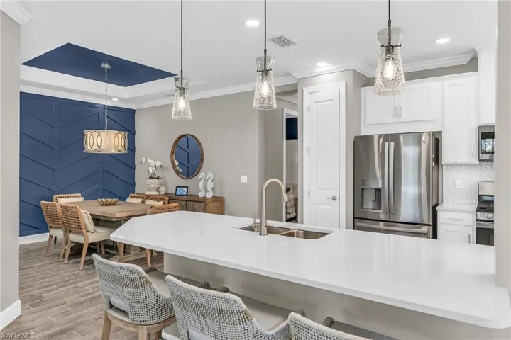 Kitchen with appliances with stainless steel finishes, light countertops, white cabinetry, and a sink
