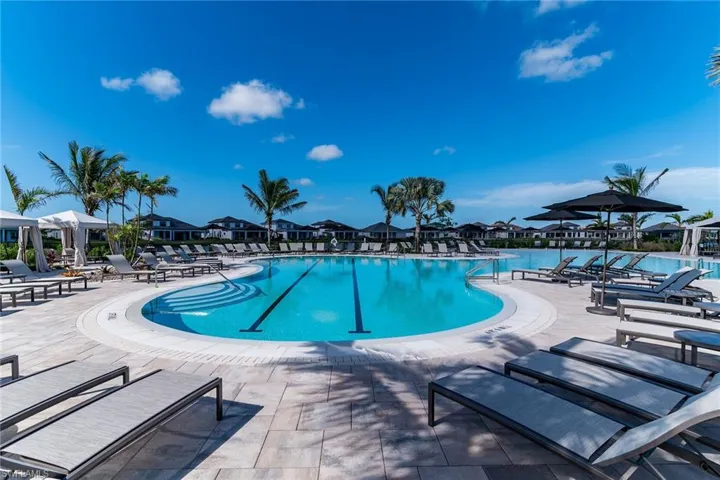 Community pool featuring a water view, a residential view, and a patio