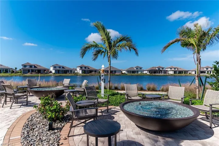 View of patio / terrace featuring a water view, an outdoor fire pit, and a residential view