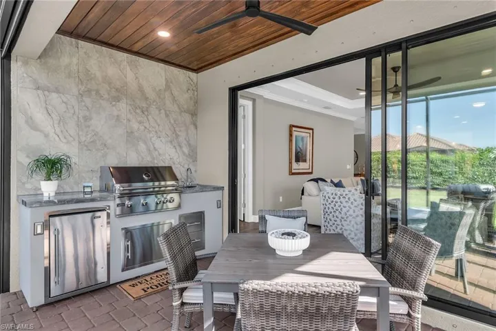 View of patio with an outdoor kitchen, outdoor dining area, area for grilling, and a ceiling fan