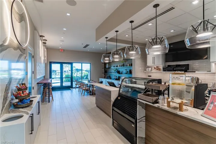 Kitchen with light stone counters, recessed lighting, backsplash, and pendant lighting