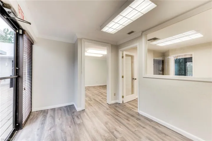 Empty room featuring light wood-type flooring and ornamental molding