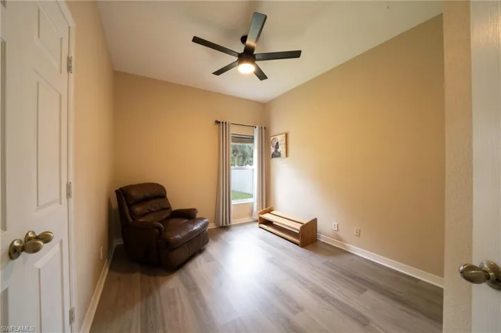 Living area with wood finished floors, a ceiling fan, and baseboards