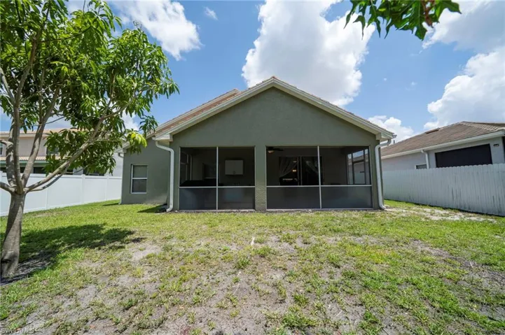 Rear view of house featuring a sunroom and stucco siding
