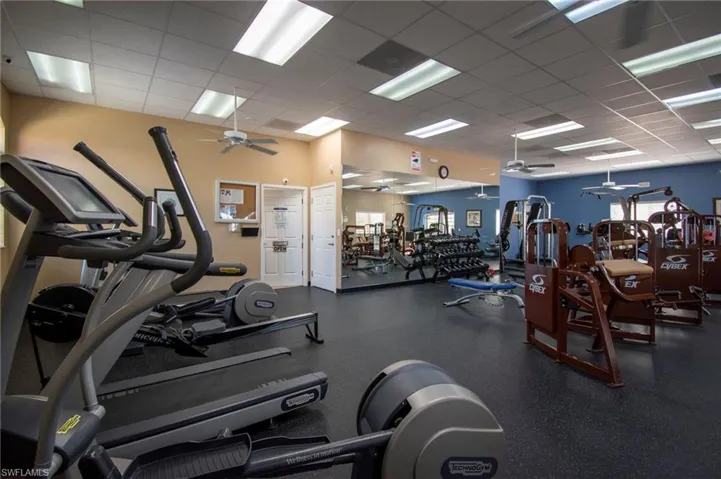 Workout area with a ceiling fan and a paneled ceiling