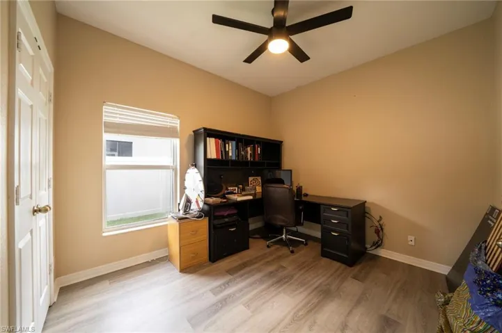 Office area with a ceiling fan, light wood-style flooring, and baseboards