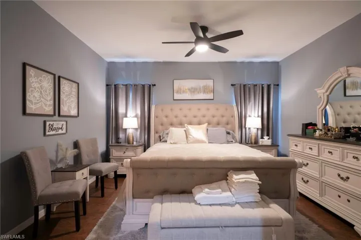 Bedroom with a ceiling fan and dark wood finished floors