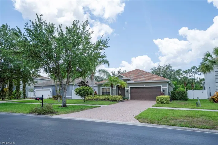 View of front of home with a garage, driveway, and stucco siding