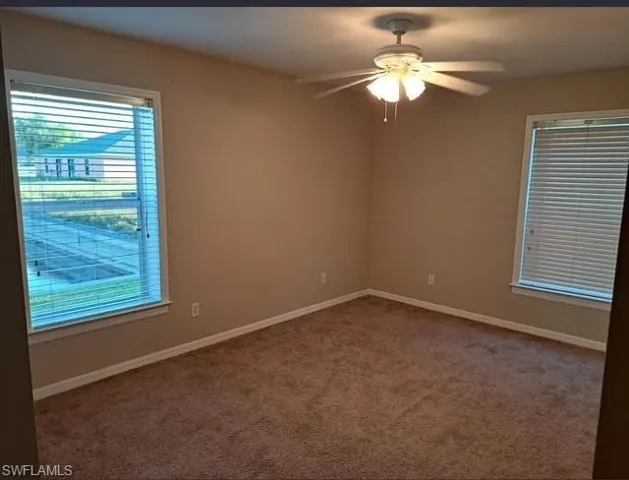 Empty room featuring carpet flooring and ceiling fan