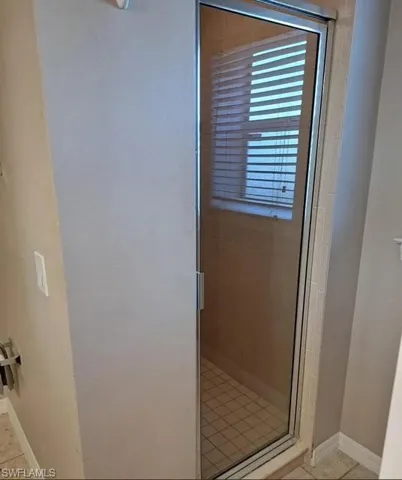 Bathroom featuring a shower stall and light tile patterned floors