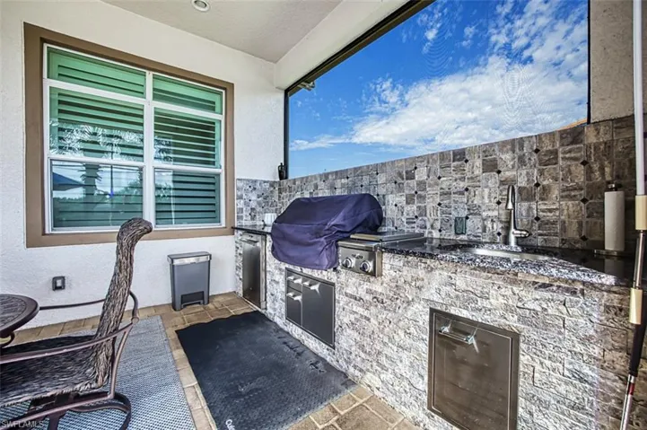 View of patio featuring area for grilling, sink, and an outdoor kitchen