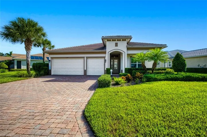 View of front of house with a garage and a front lawn