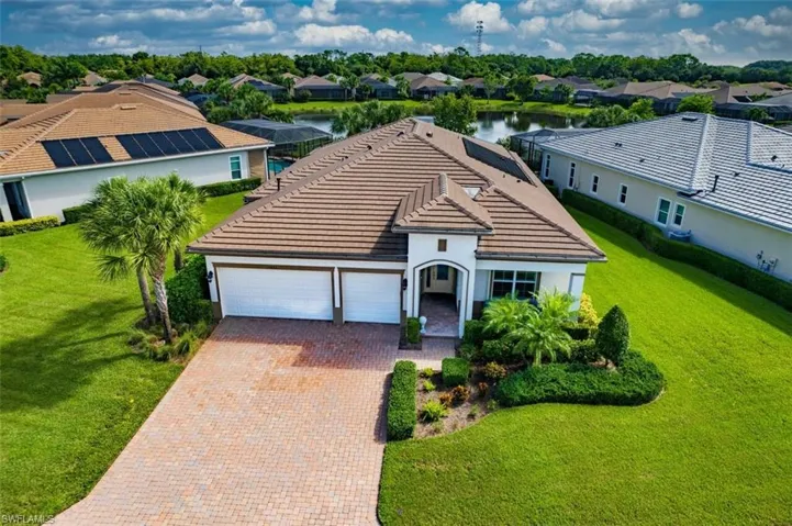 View of front of house with a water view, a garage, and a front yard