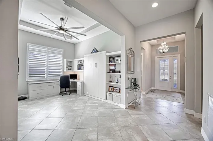 Unfurnished office with light tile patterned floors and an inviting chandelier