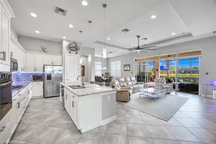Kitchen featuring appliances with stainless steel finishes, sink, plenty of natural light, and an island with sink