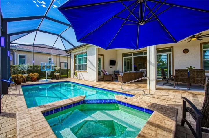View of pool with ceiling fan, a lanai, an in ground hot tub, and a patio area