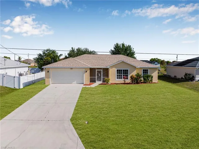 Single story home with driveway, a front yard, fence, and stucco siding