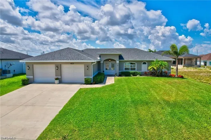 Ranch-style house featuring a garage and a front lawn