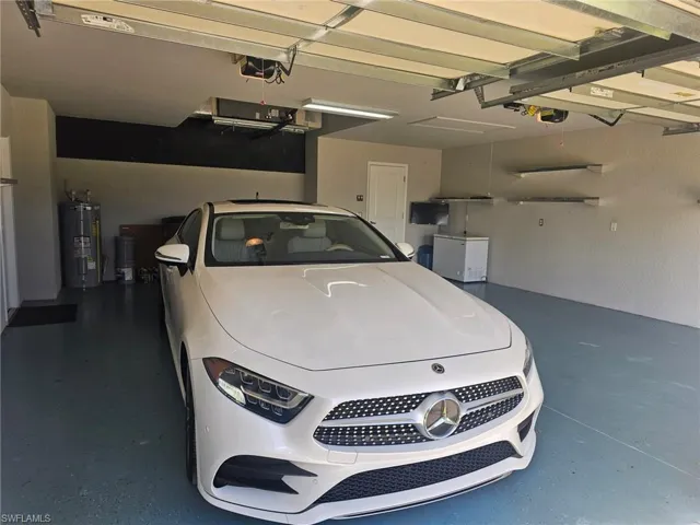 Garage featuring water heater and a garage door opener