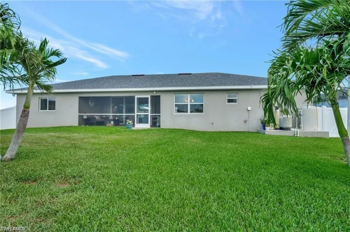 Back of property with a sunroom and a yard