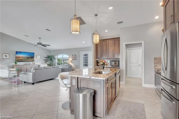 Kitchen with appliances with stainless steel finishes, sink, pendant lighting, a kitchen island with sink, and ceiling fan
