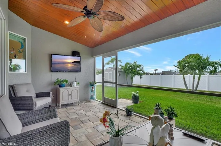 Sunroom / solarium with ceiling fan, vaulted ceiling, and wooden ceiling