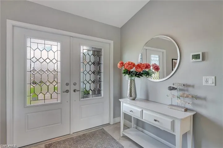 Tiled entrance foyer featuring vaulted ceiling, french doors, and plenty of natural light