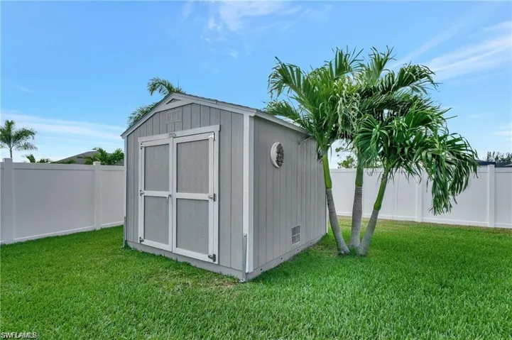 View of outbuilding featuring a lawn