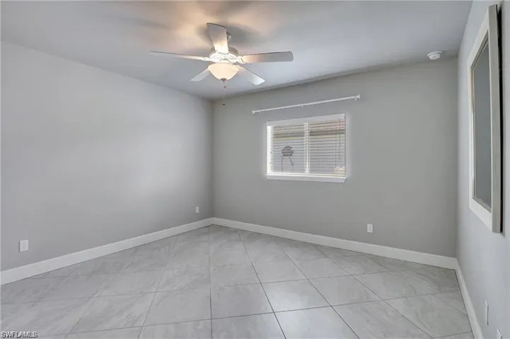 Tiled empty room with ceiling fan