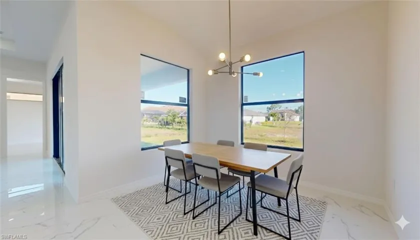 Dining space with light marble finish flooring, a chandelier, and lofted ceiling