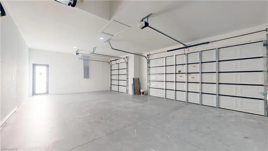 Garage featuring electric panel and a garage door opener
