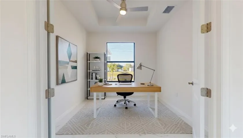 Office featuring a tray ceiling and a ceiling fan