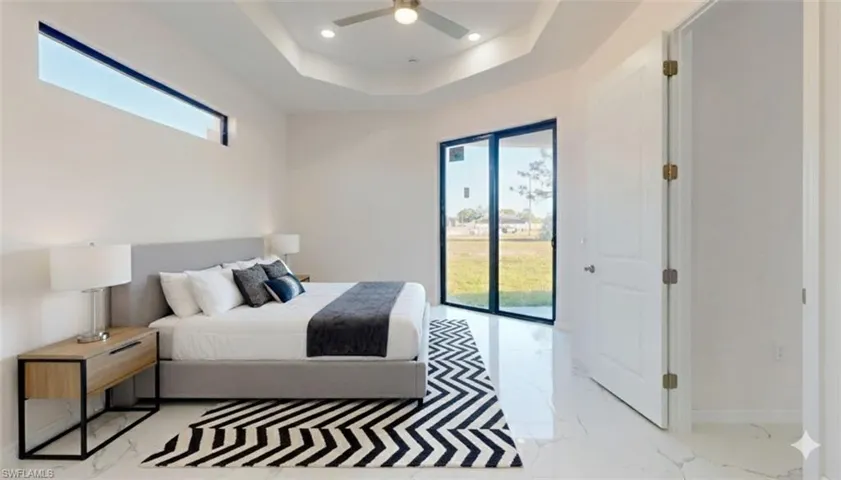 Bedroom featuring light marble finish floors, access to exterior, a raised ceiling, ceiling fan, and recessed lighting