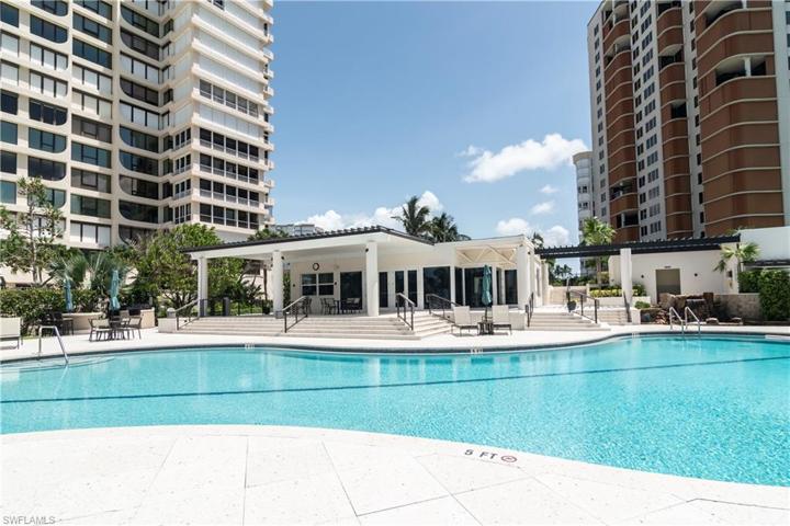 View of pretty, sunny pool and looking to Park Shore Tower community room.