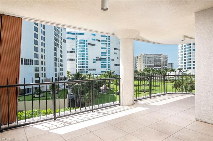 This spacious lanai offers compelling views of a Park Shore park and the gulf beyond.