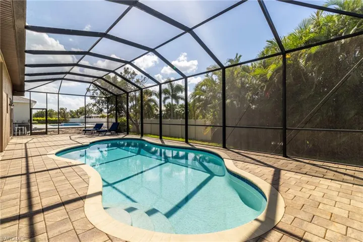 View of swimming pool with a patio area and a lanai