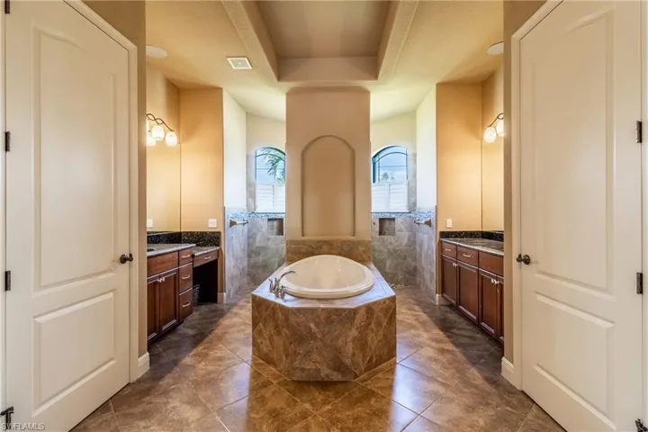 Bathroom featuring tile patterned flooring, vanity, and separate shower and tub