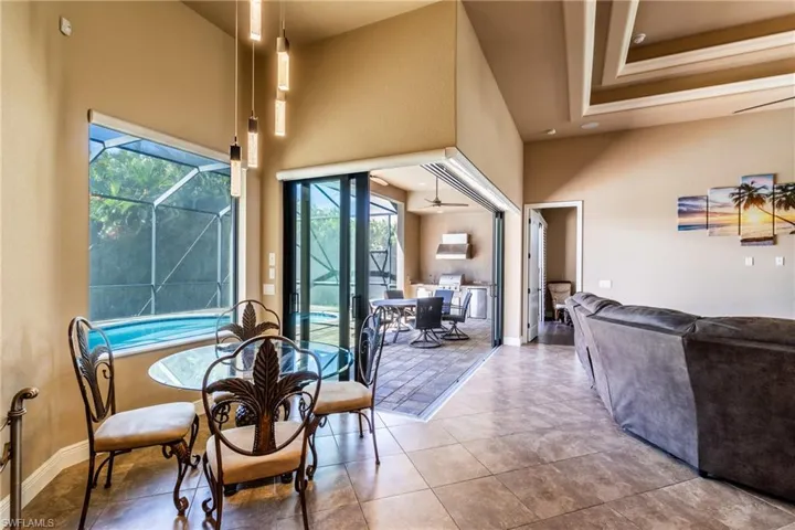 Dining room with ceiling fan, a high ceiling, and light tile patterned floors