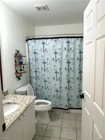 Bathroom featuring vanity, tile patterned floors, and curtained shower