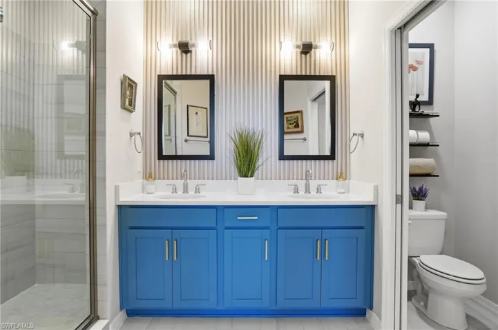 Bathroom featuring double vanity and a shower stall