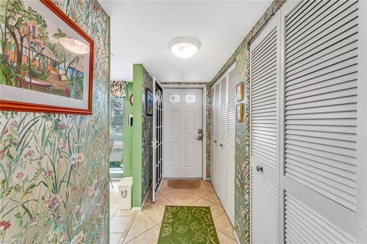 Foyer looking towards front entrance.  Washer & Dryer to the right behind louver doors.