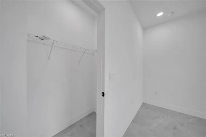 Walk in closet with light marble finish floors