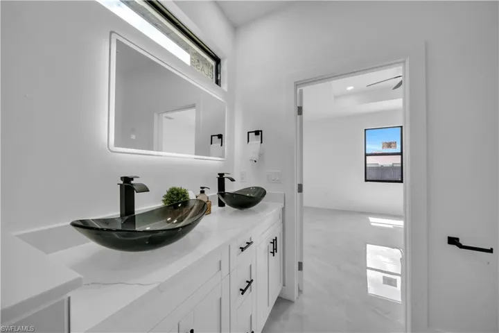 Full bathroom featuring double vanity and healthy amount of natural light