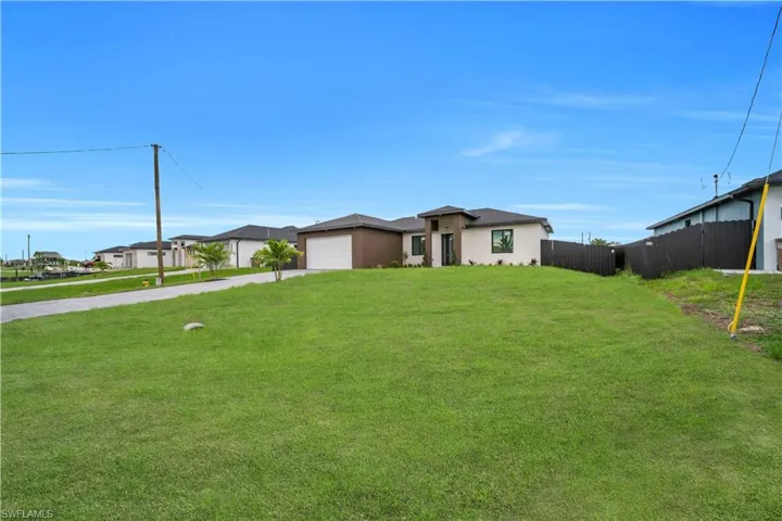 View of front of property featuring driveway, stucco siding, and an attached garage