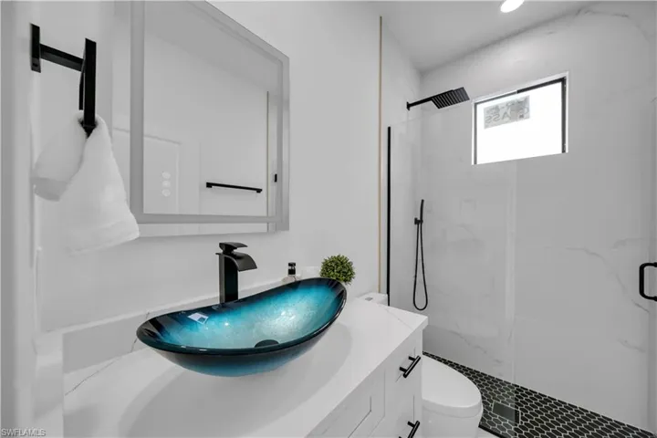 Bathroom with a marble finish shower and vanity