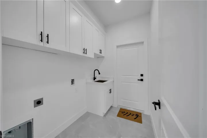 Washroom featuring electric dryer hookup and cabinet space