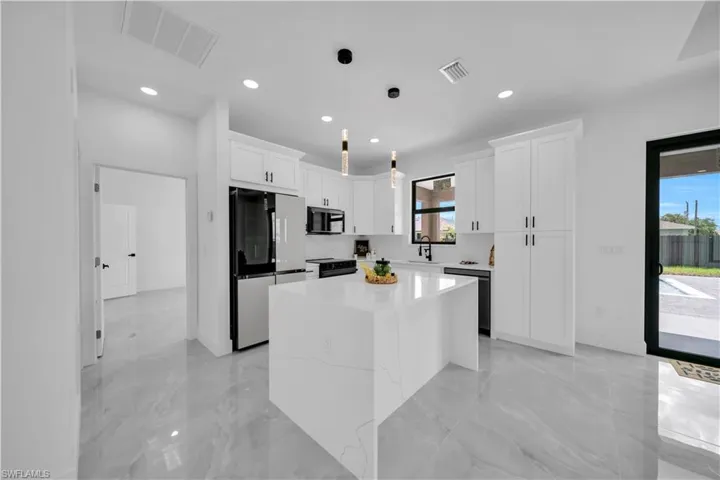 Kitchen featuring stainless steel microwave, refrigerator, dishwasher, healthy amount of natural light, and recessed lighting