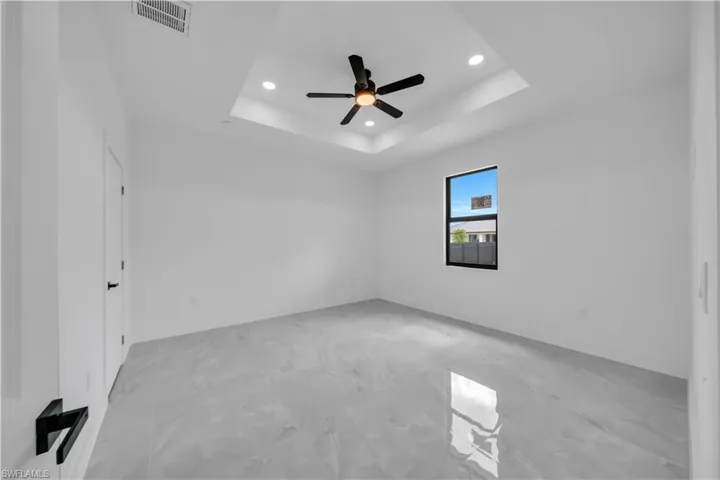Empty room featuring recessed lighting, a raised ceiling, and ceiling fan